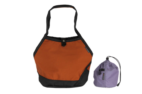 The Swift in Burnt Orange Ballistic with a Dawn (blue-grey with dark blue-grey grid) interior and Medium Yarn Stuff Sack